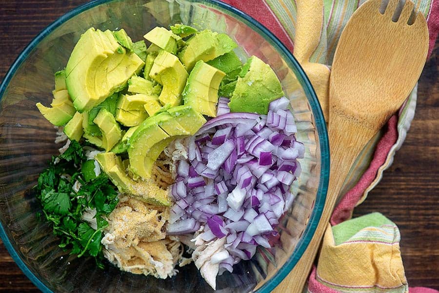 ingredients for healthy chicken salad in glass bowl