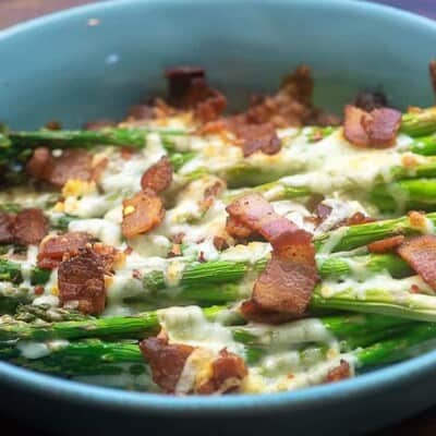 bacon and asparagus in blue dish.