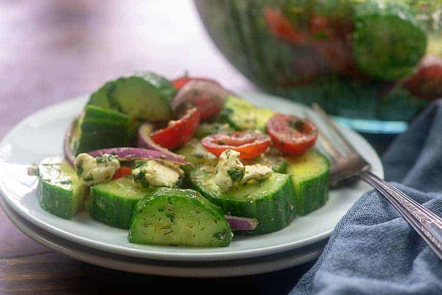 cucumber tomato salad on white plate