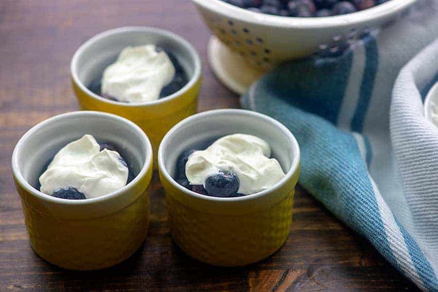 blueberries with sour cream in yellow ramekins