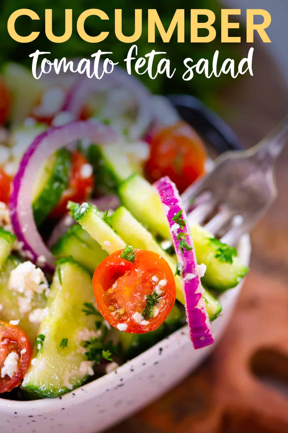 Fork dipping into a bowl of cucumber salad.