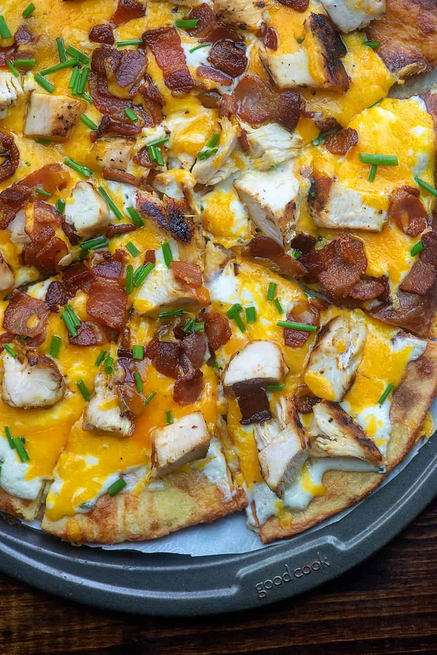 Overhead view of chicken bacon ranch pizza cut into triangle pieces