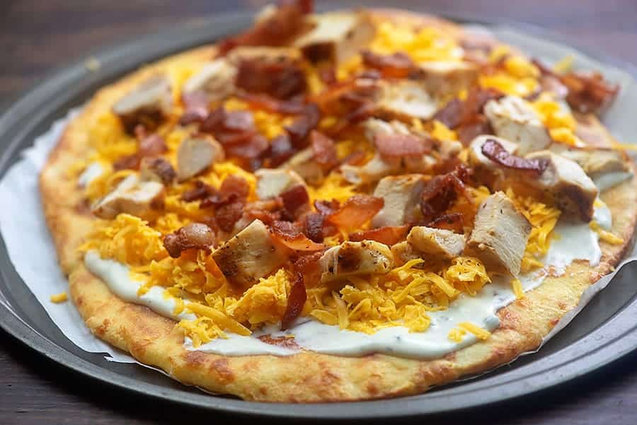chicken pizza with ranch and bacon on pizza pan.