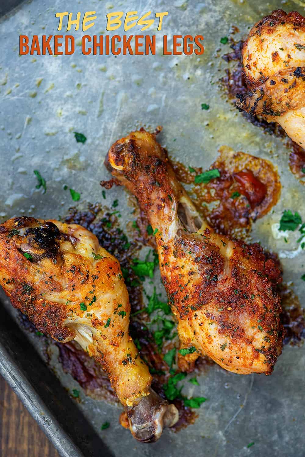 An overhead view of chicken drumsticks spread out on a baking sheet.