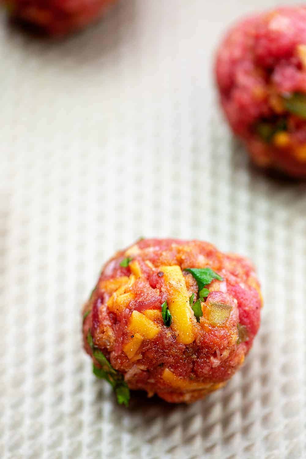 raw meatball on a baking sheet