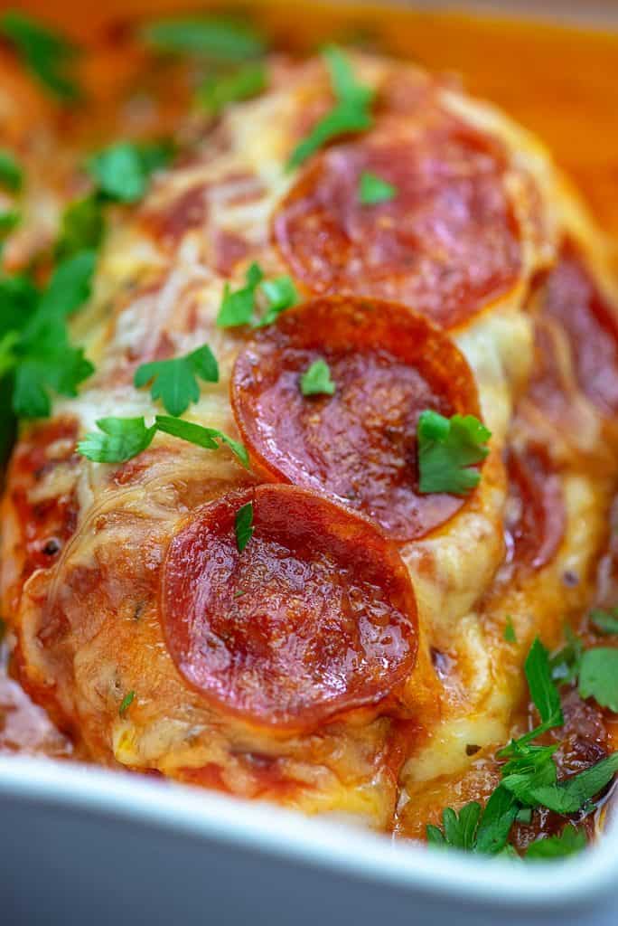 pepperoni topped chicken in a white baking pan