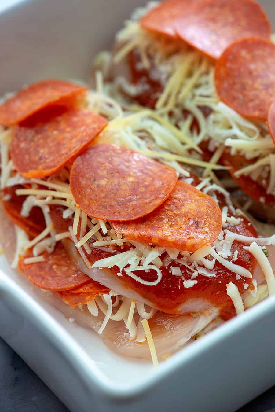 pepperoni and cheese stuffed chicken breasts in baking dish