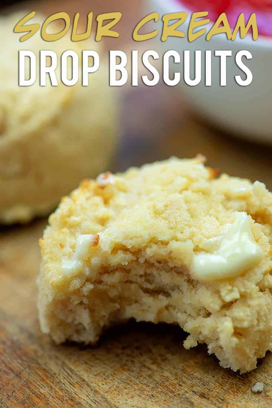 sour cream biscuit with butter melting on it with a bite taken out of it
