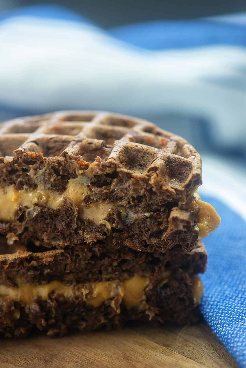 two waffles with peanut butter in the middle on a cutting board