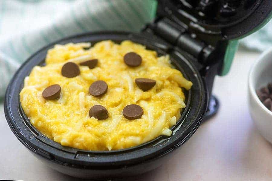 cheese, eggs, and chocolate chips in a small waffle iron
