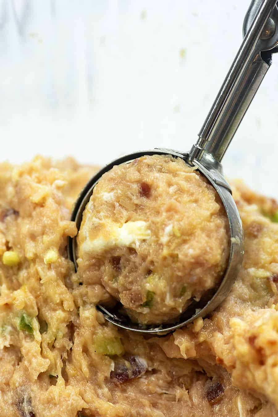 scooping turkey meatball mix with a large cookie scoop