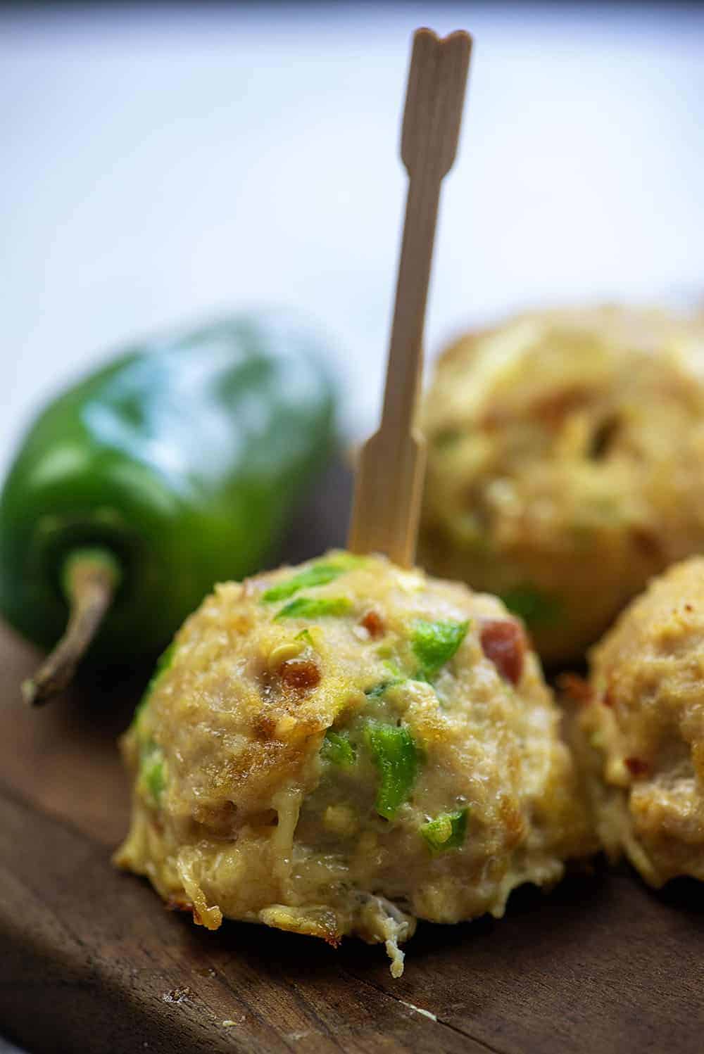 Jalapeno popper meatball on wooden skewer.