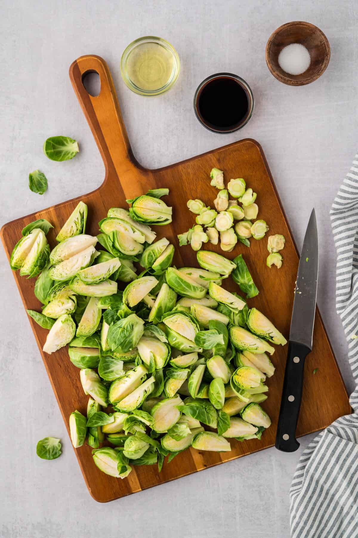 Quartered brussels sprouts on cutting board.