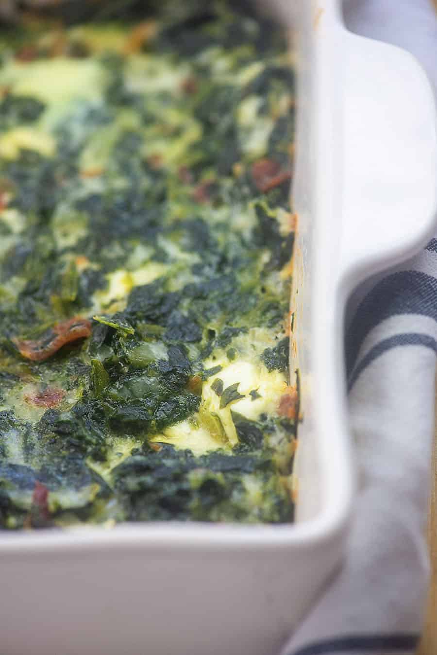 baked spinach casserole in a white baking sheet