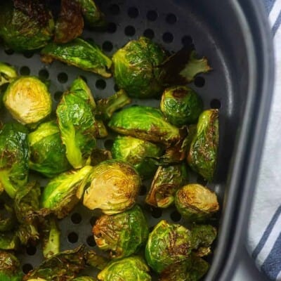 A bunch of Brussel sprouts in an air fryer basket