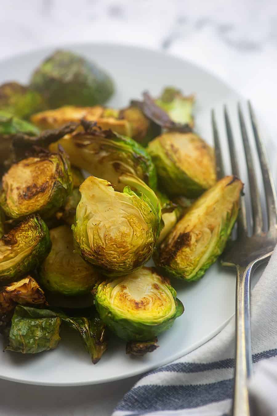 air fried brussel sprouts on a white plate with a fork