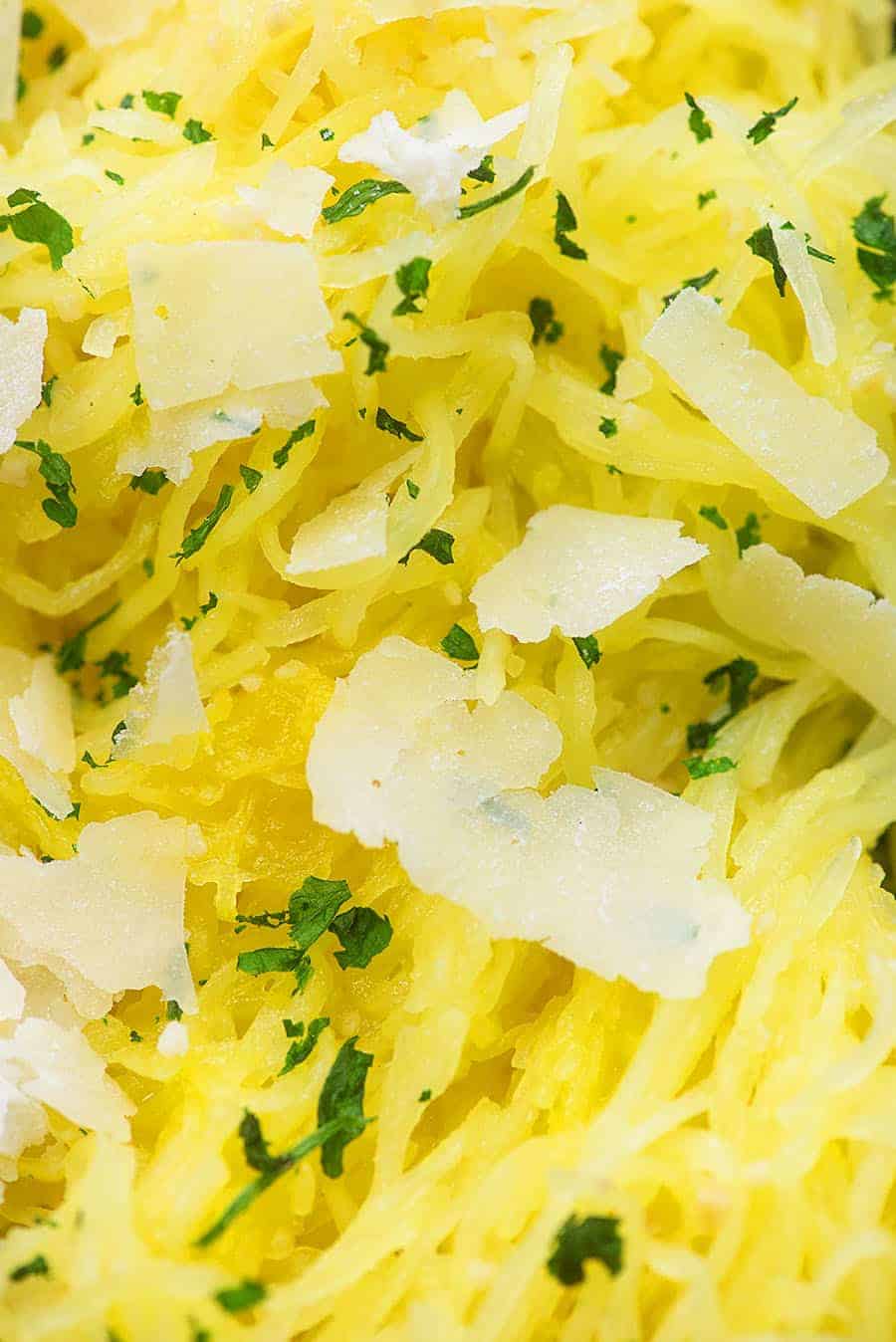 A close up of spaghetti squash with flakes of parmesan cheese on top