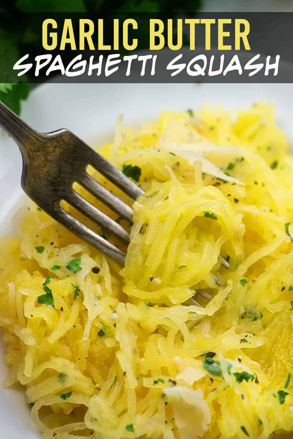 A fork dipping into a pile of spaghetti squash on a white plate.