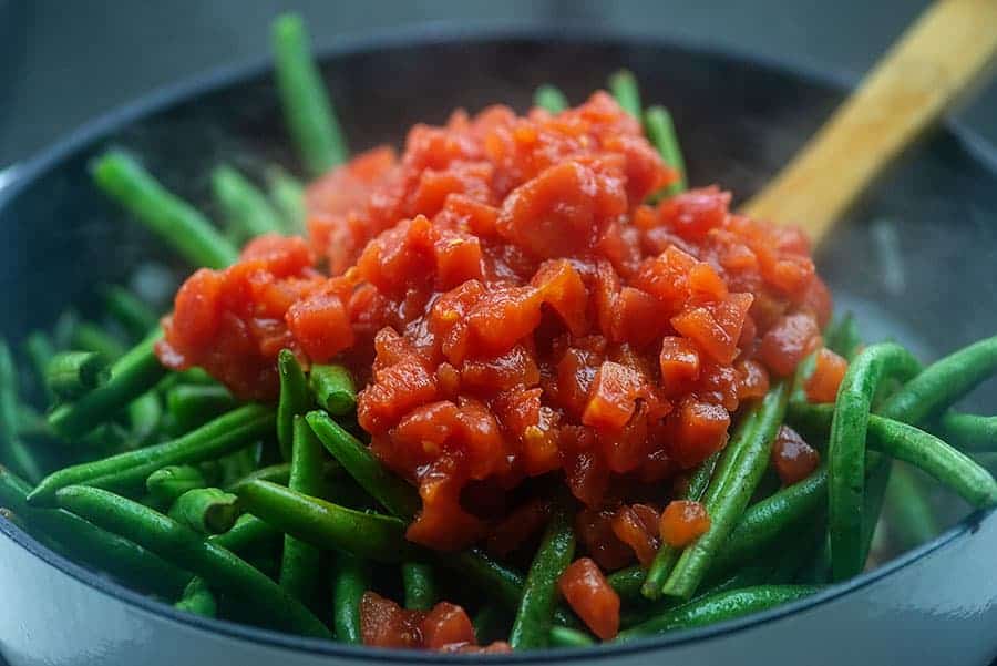 fresh green beans and tomatoes in skillet