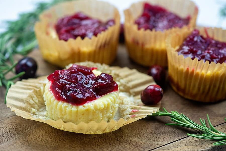 Several mini cranberry cheesecakes on a table.