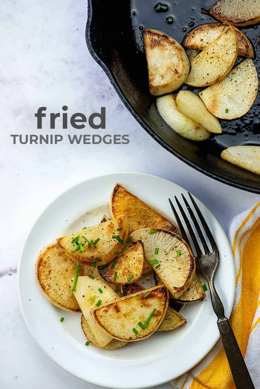 white plate of fried turnip wedges next to a cast iron skillet