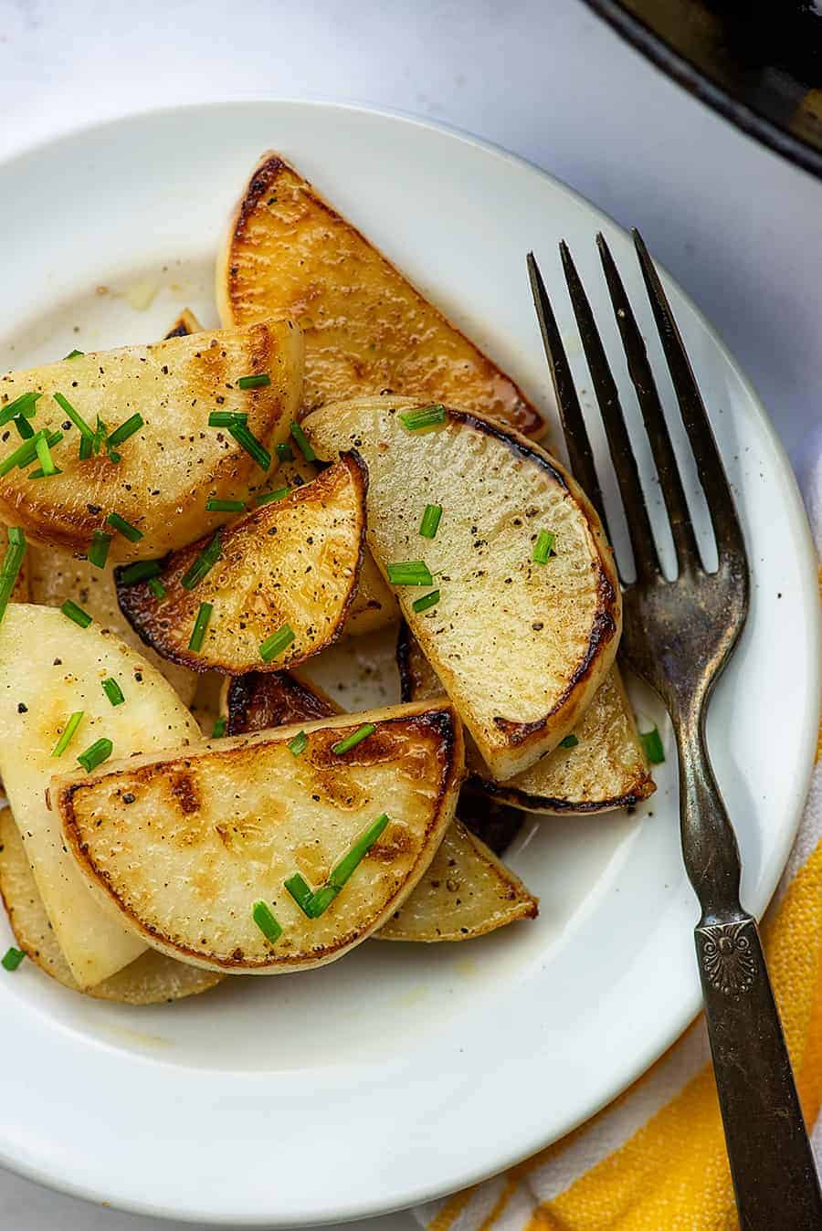 plate of fried turnips with an old fork