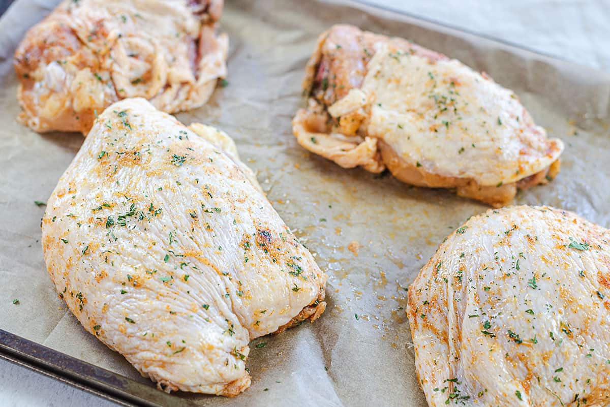 seasoned chicken thighs on sheet pan.