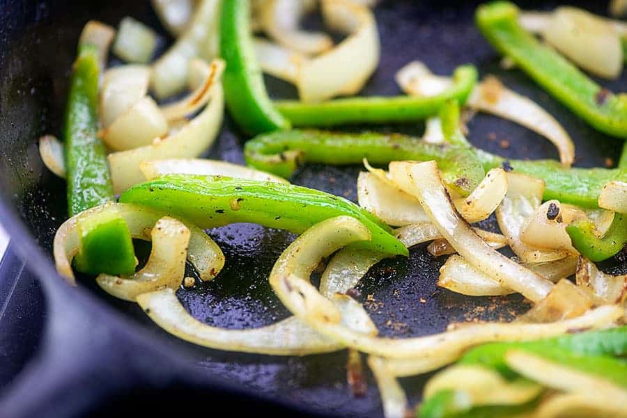 onions and peppers in cast iron skillet