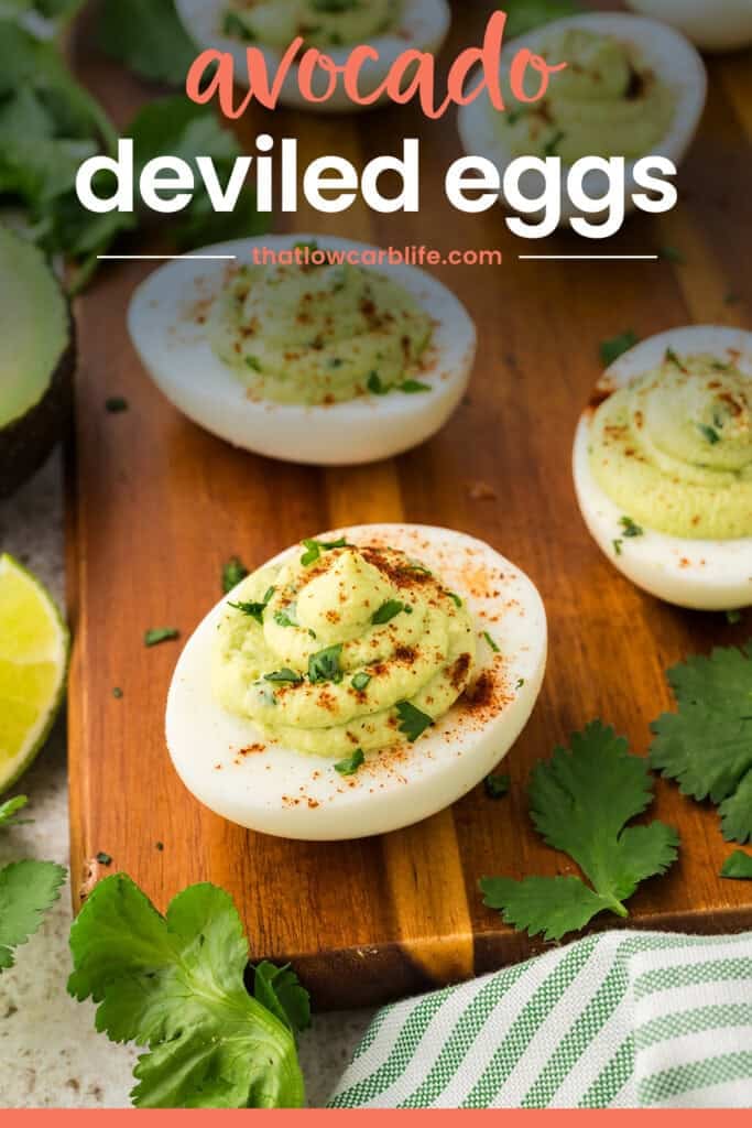 Deviled egg made with avocado instead of mayonnaise on wooden cutting board.