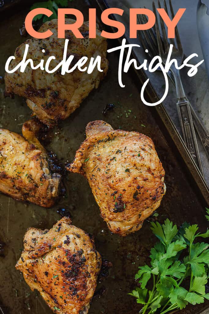 crispy chicken thighs on sheet pan with text for Pinterest.