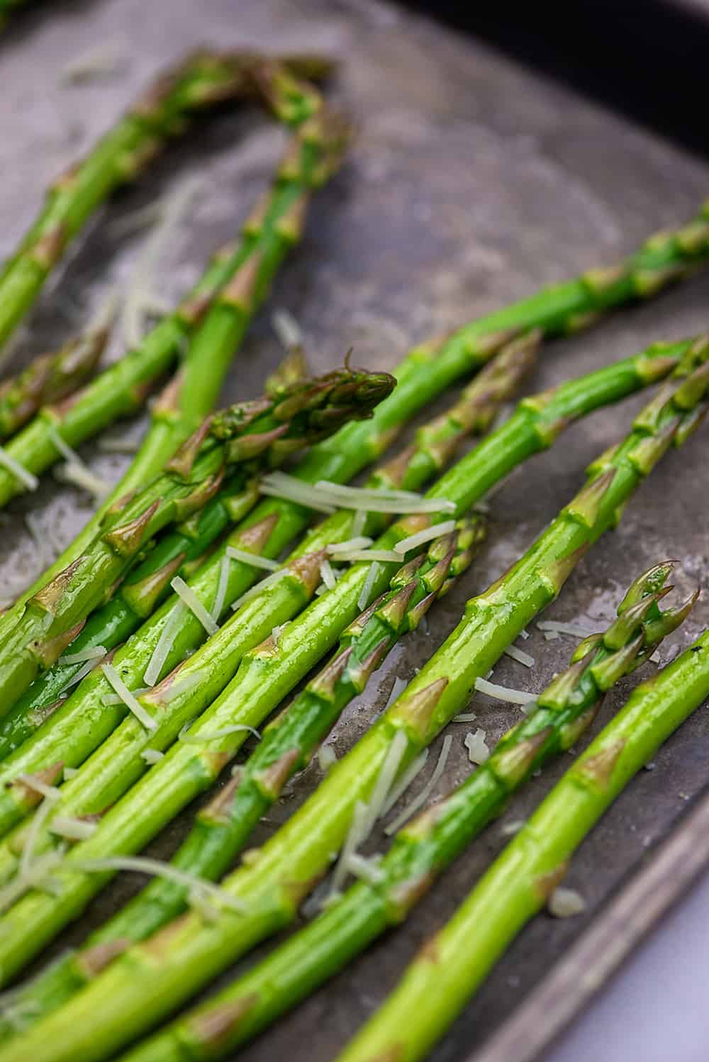 asparagus on baking sheet with garlic and parmesan