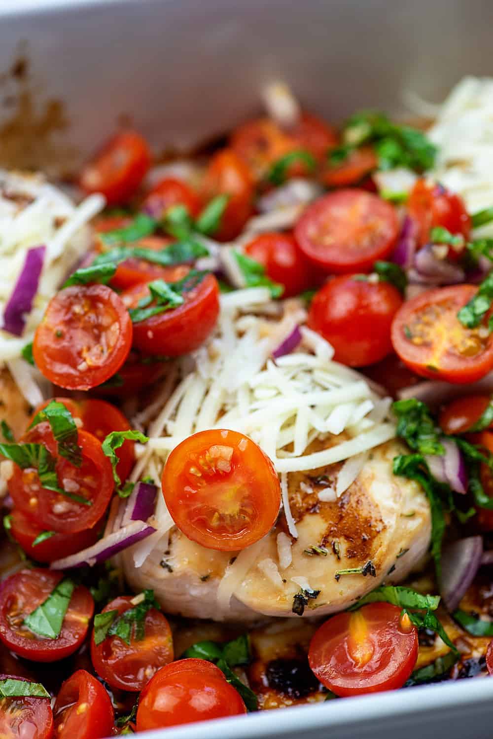 baked chicken with cheese and tomatoes on top