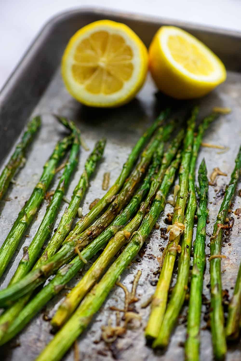 oven roasted asparagus with lemons on baking sheet