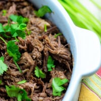 slow cooker shredded beef with cilantro in white dish