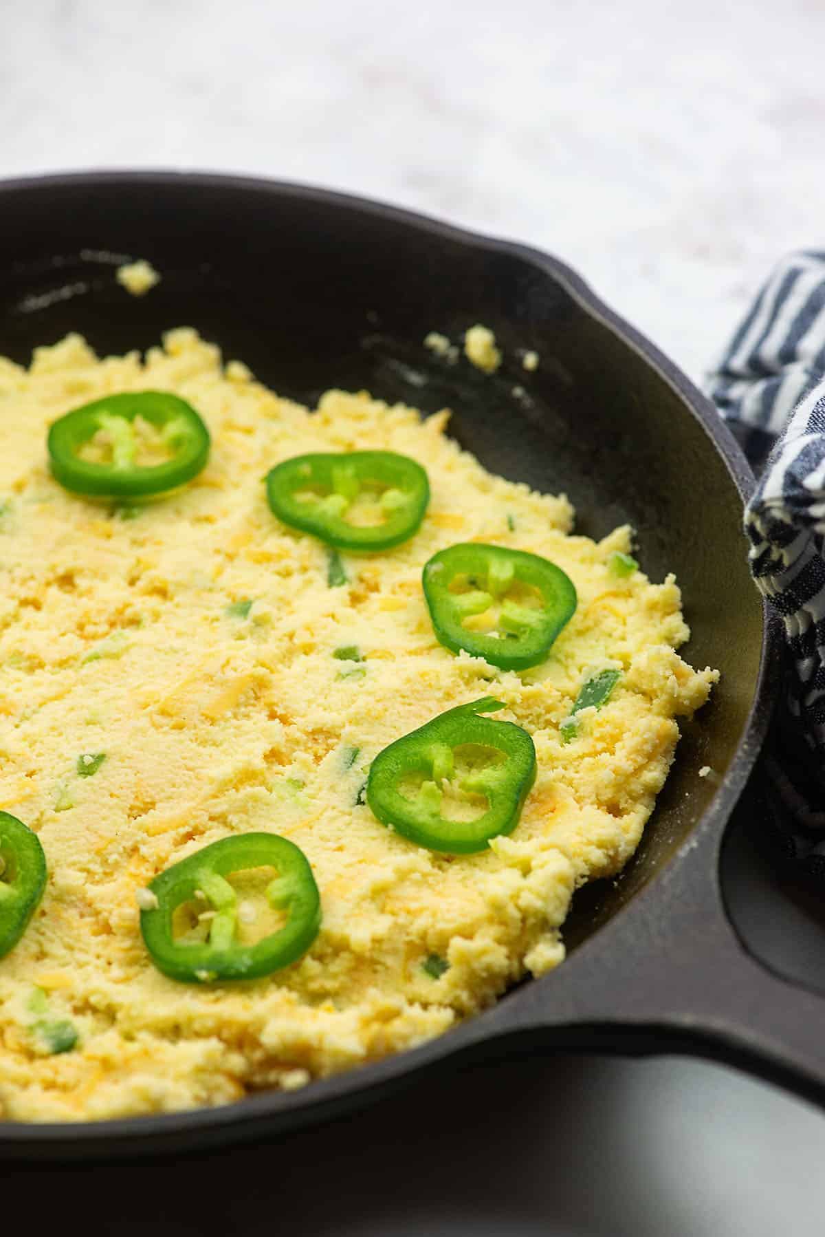 keto cornbread with jalapeno slices in cast iron skillet