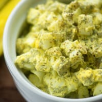egg salad recipe with dill and pickles in white bowl