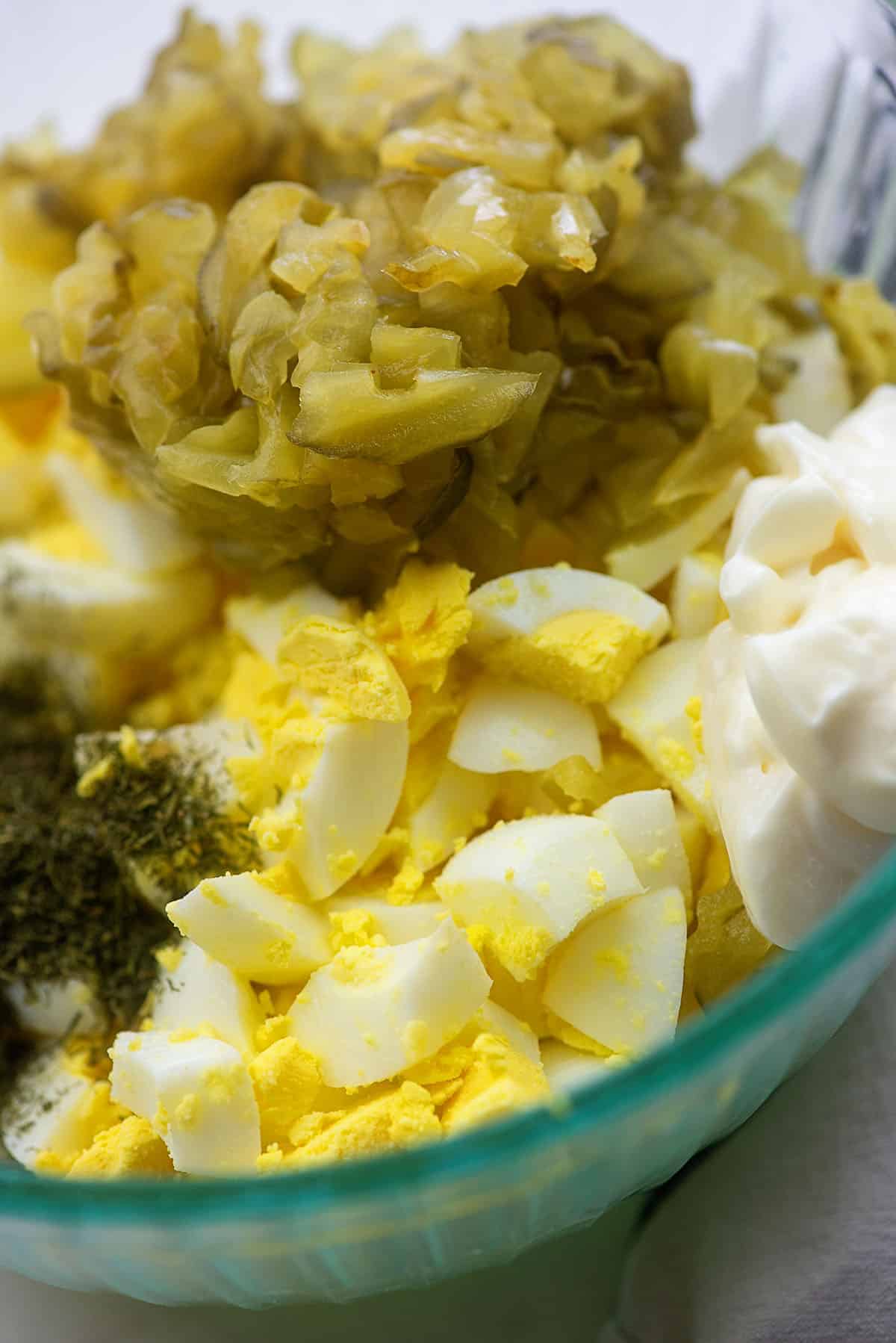 ingredients for dill pickle egg salad in glass bowl