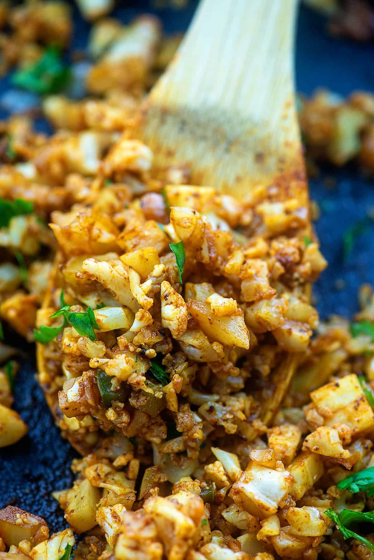 cauliflower mexican rice in skillet on wooden spoon