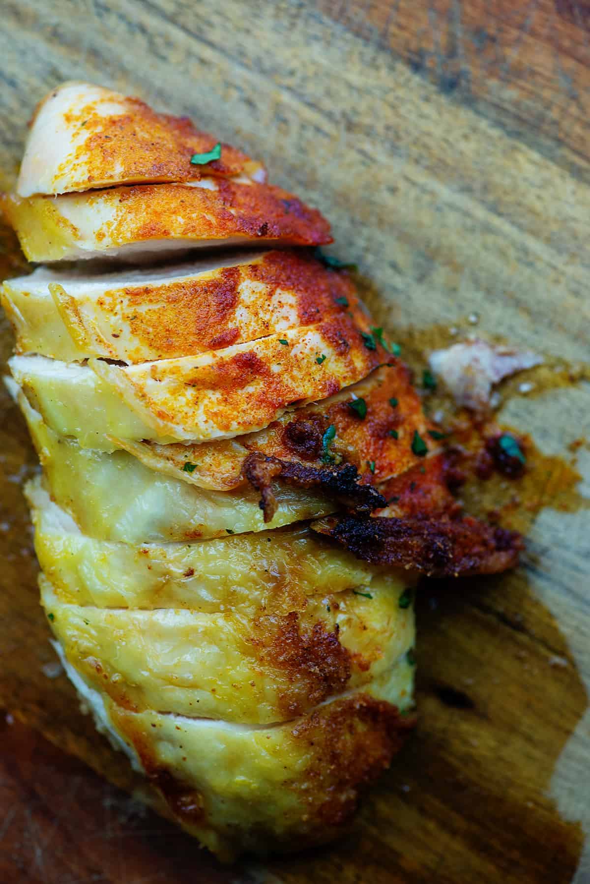 petti di pollo arrosto su tagliere di legno