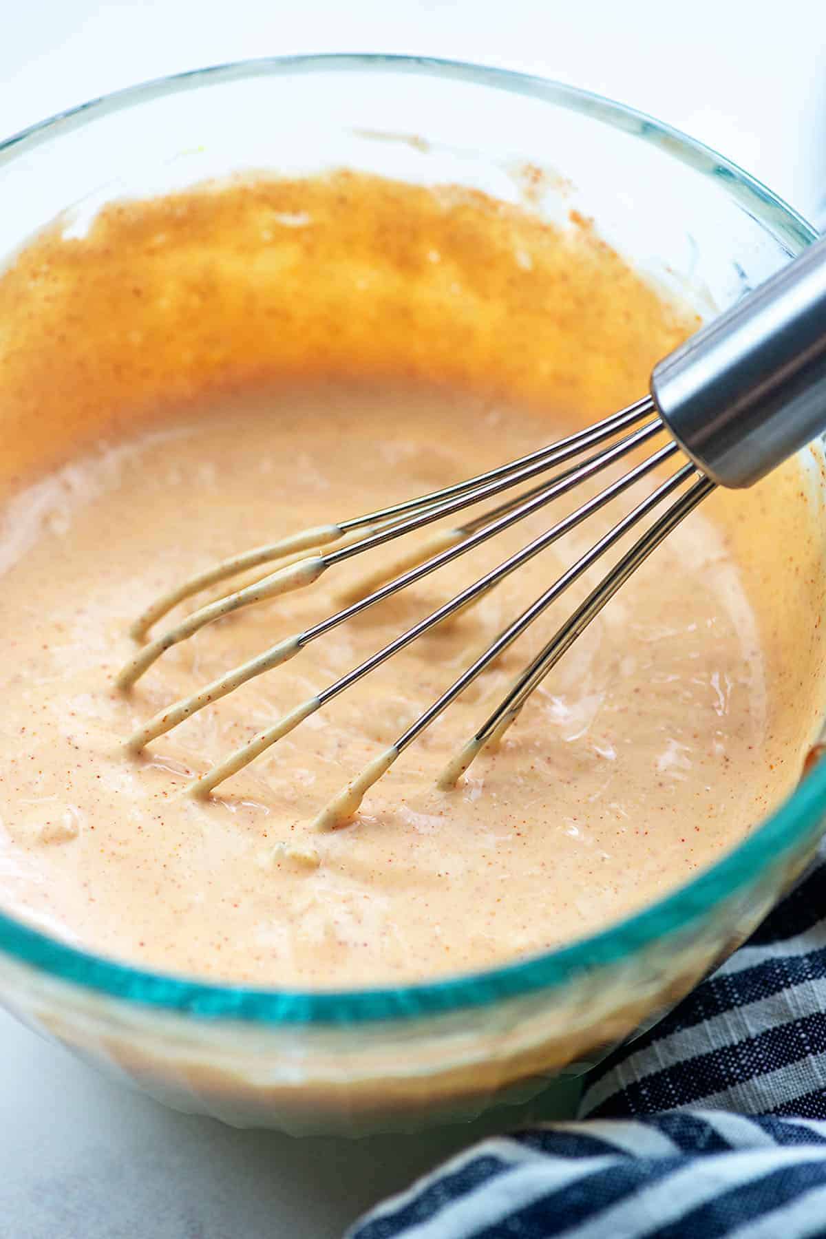 big mac salad dressing in glass bowl with wire whisk