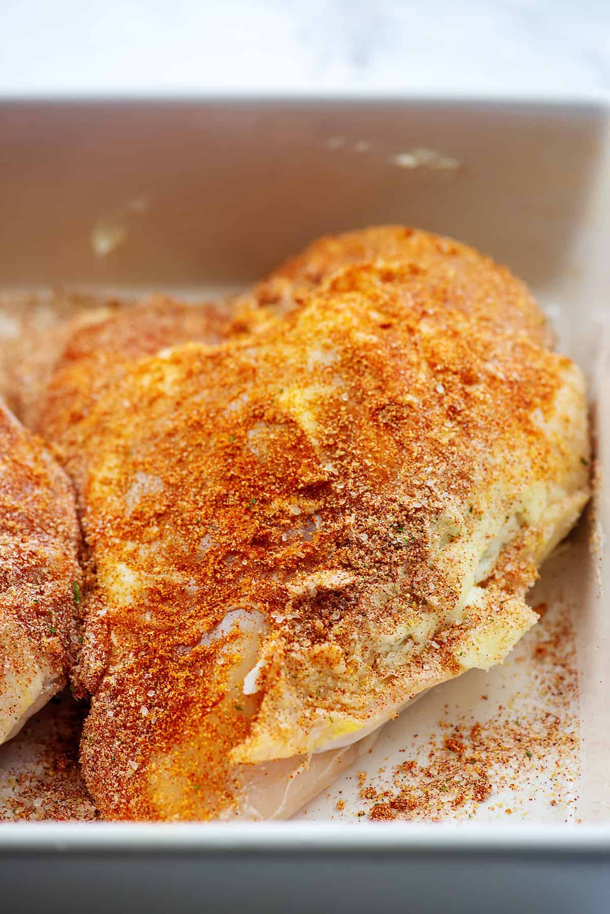 chicken coated in butter and seasonings for roasting