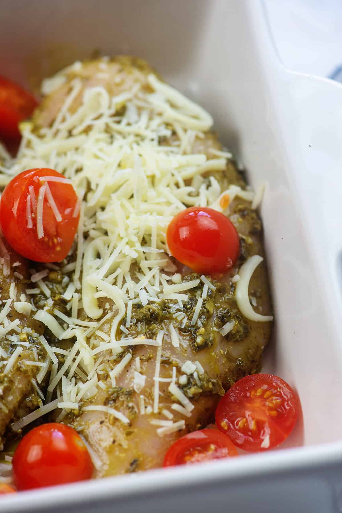 chicken breasts with cheese and tomatoes in baking dish