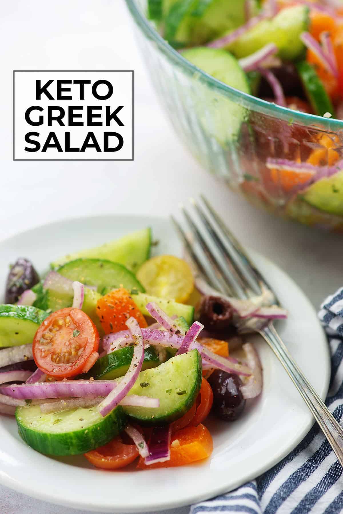 keto greek salad on white plate with blue striped napkin