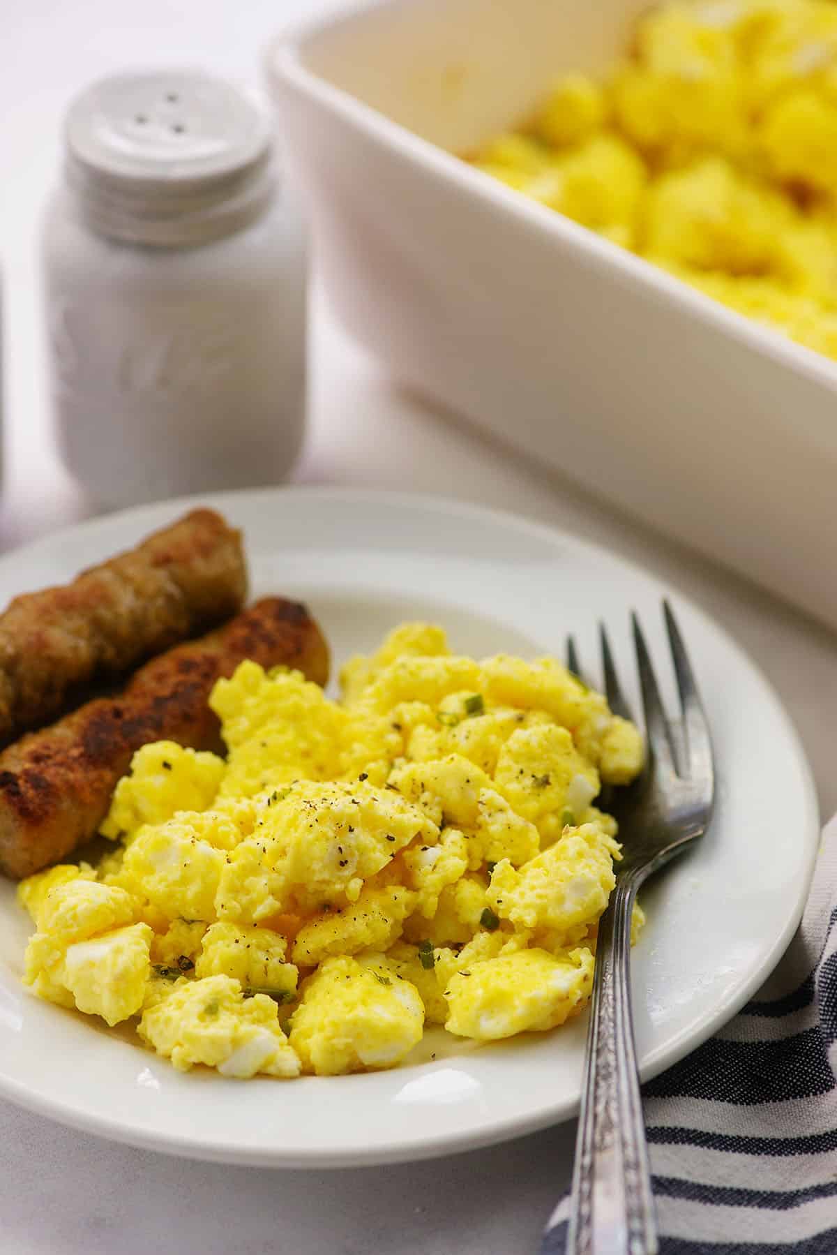 scrambled egg recipe on white plate with sausage