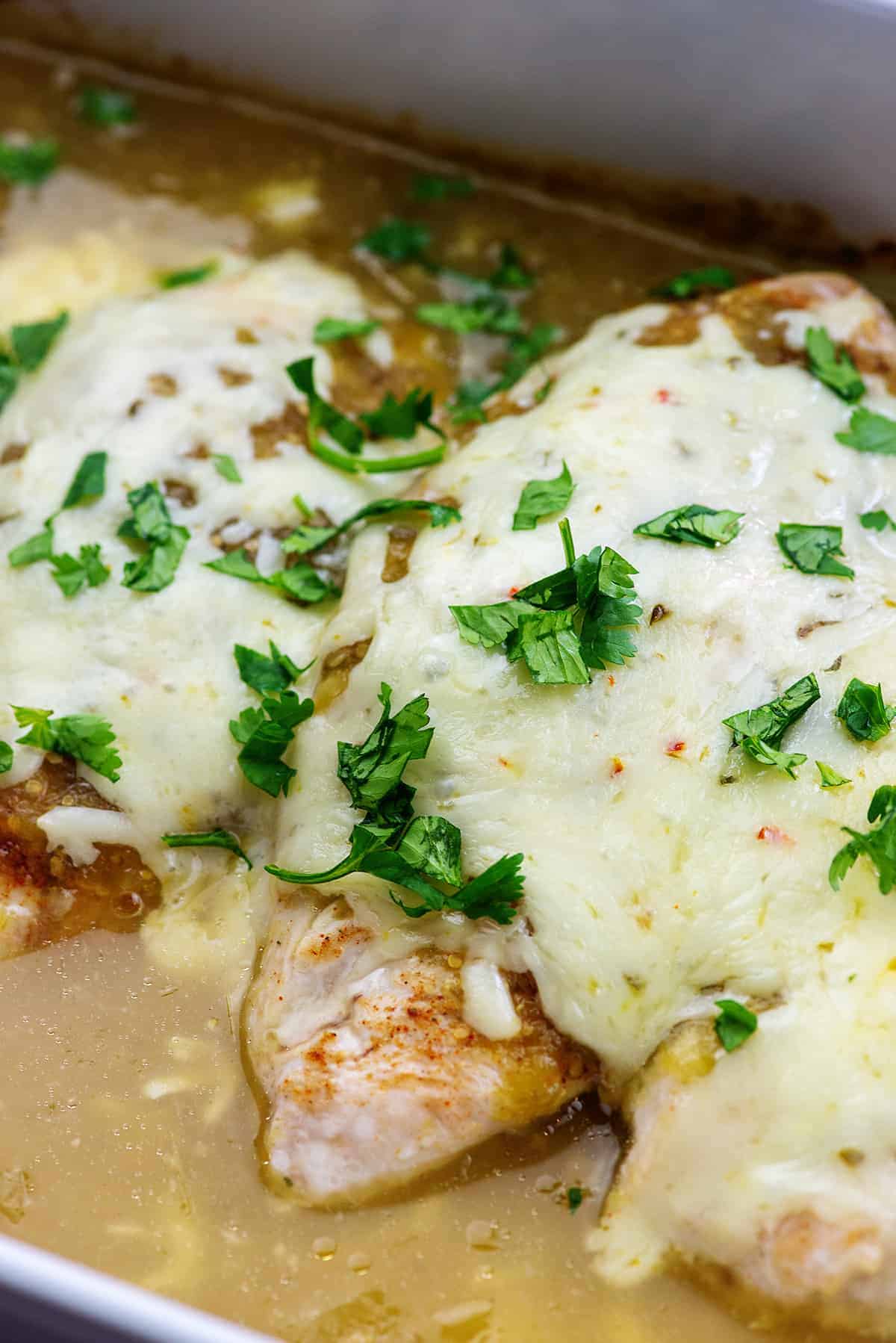 cheesy chicken baked in a dish of salsa verde