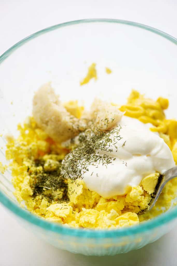 ingredients for deviled eggs in glass mixing bowl