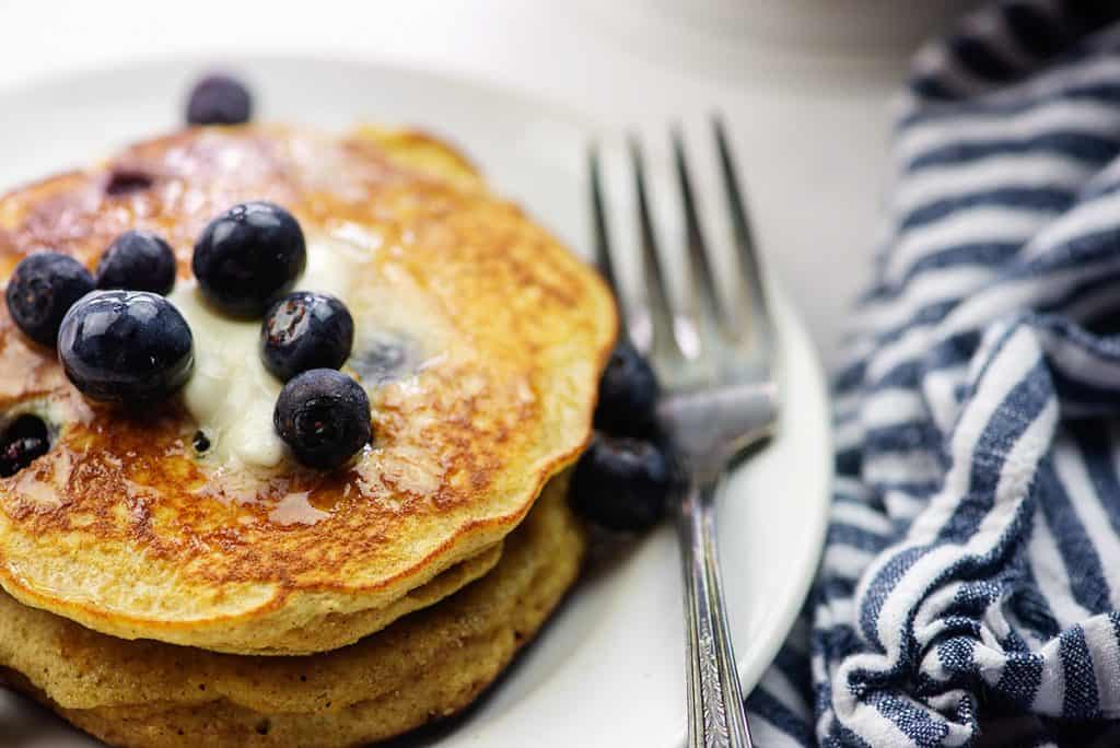 blueberry pancake recipe on white plate with vintage fork