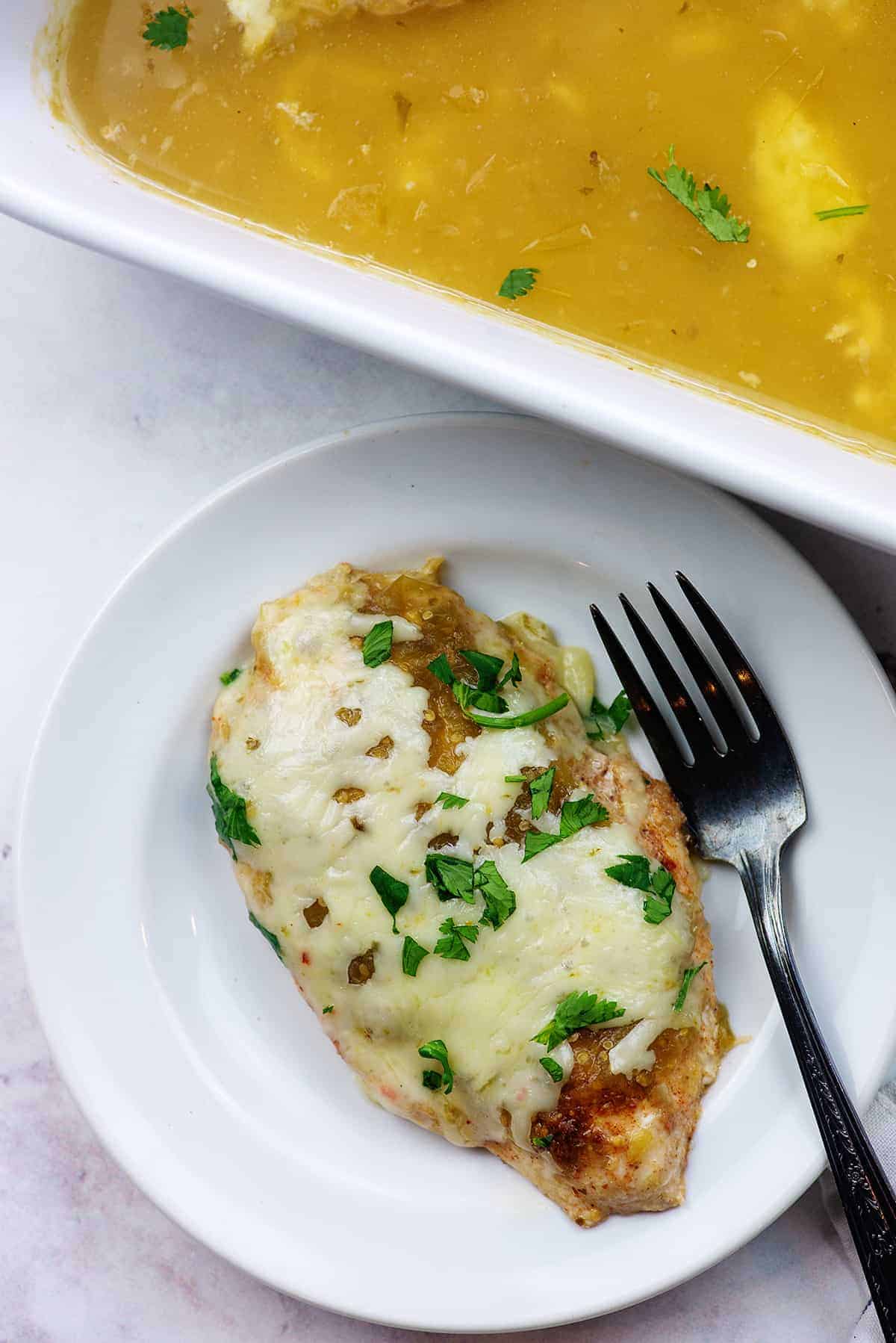 cheesy salsa verde chicken on white plate