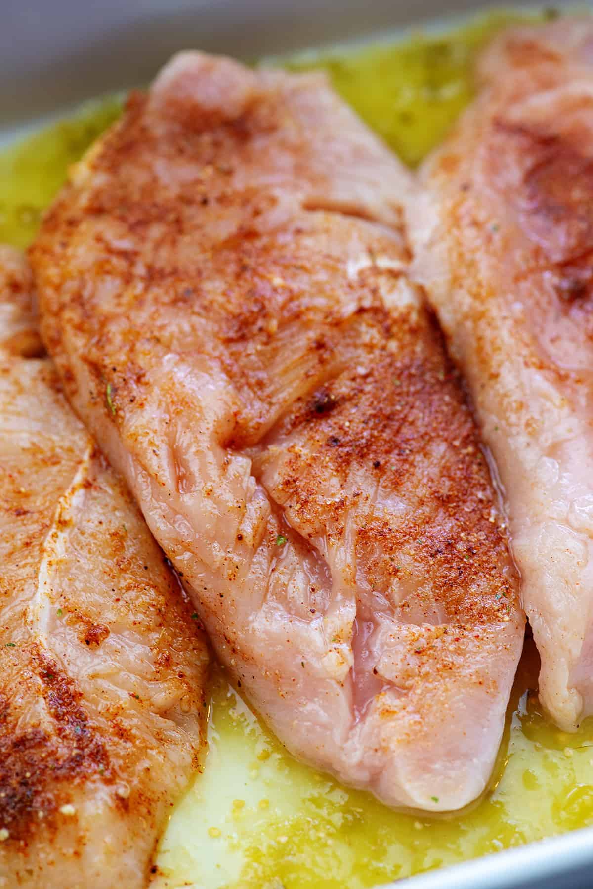 seasoned chicken breasts in white baking dish