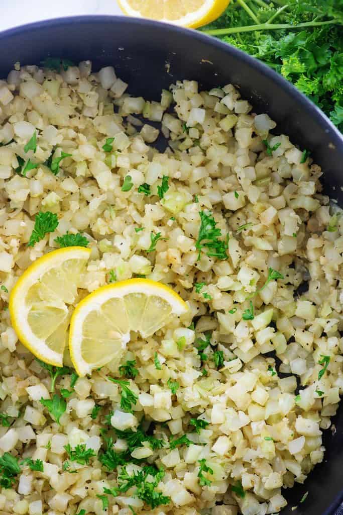 cauliflower rice in cast iron pot with lemon slices